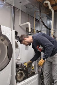 professional disassembling the motor during dryer repairs