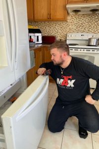 technician fixing broken fridge