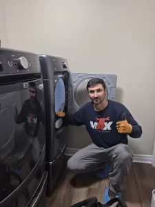 Max Appliance Repair technician beside the reassembled Maytag dryer