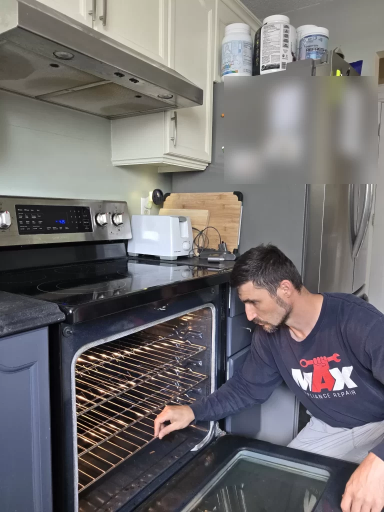 Technician inspecting the open cavity of a Samsung electric oven