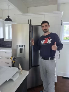 Technician beside a closed Hisense French-door refrigerator