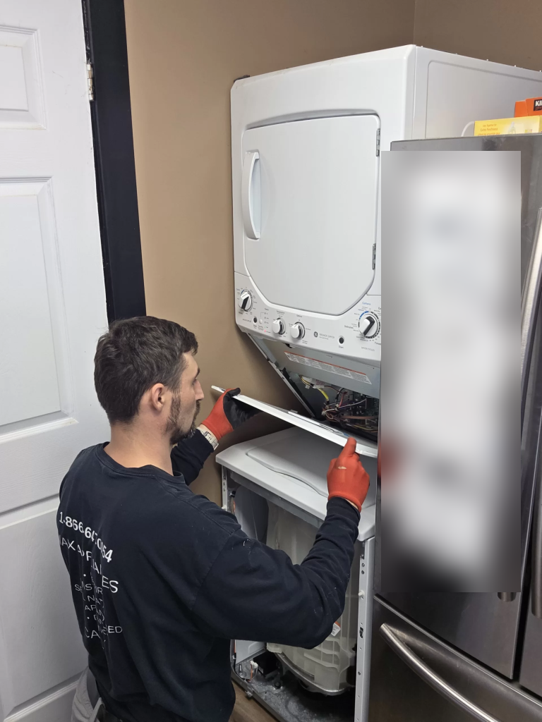 Technician holding the access cover below the GE laundry center controls