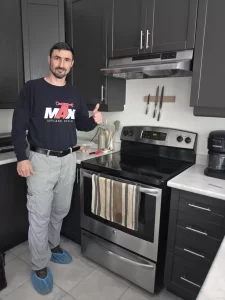 Max Appliance Repair technician beside the completed GE electric oven repair
